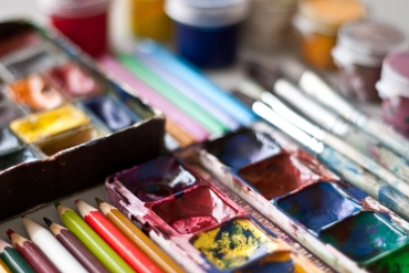 Items for drawing and art: watercolor paint brushes colored pencils.