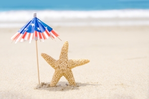 Patriotic USA background with starfishes and decorations on the sandy beach